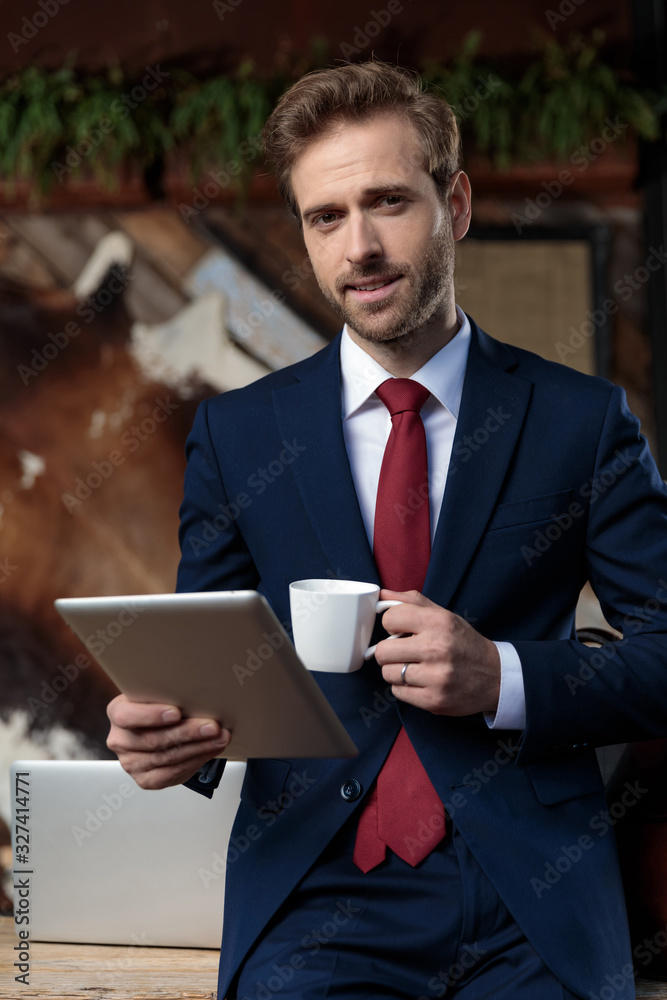 sexy businessman drinking coffee and holding tab sexy businessman drinking coffee and holding tab