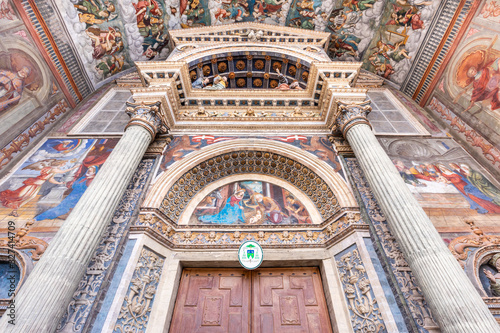 Wide low angle view of the colorful frescoed portal leading to the medieval cathedral of Aosta