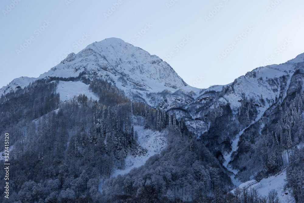 New winter season has started. Snowy mountain peaks landscape. Cloudless sky. Russia, Sochi