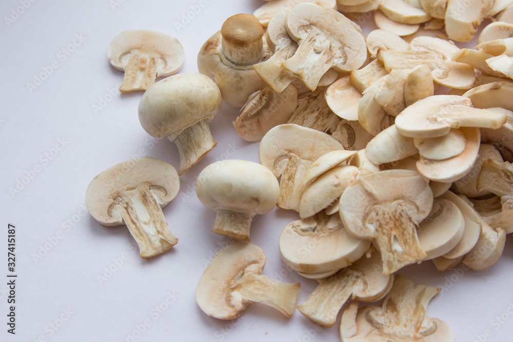 Raw fresh cut mushrooms at white background of the table Raw fresh cut mushrooms at white background of the table