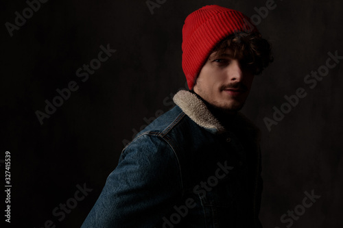 happy young guy wearing red hat and denim jacket