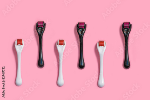 Micro needle derma roller for home face care on light pink background photo