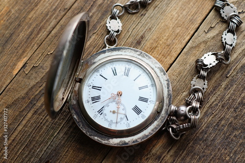 vintage silver pocket watch, old wooden background