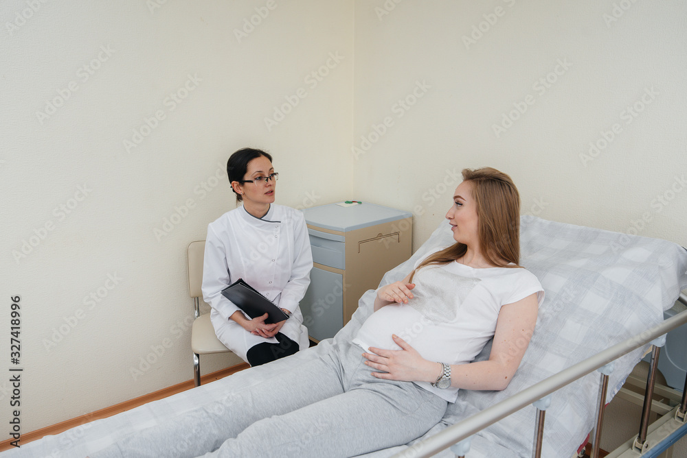 The doctor advises and serves a young pregnant girl in a medical clinic. Medical examination The doctor advises and serves a young pregnant girl in a medical clinic. Medical examination