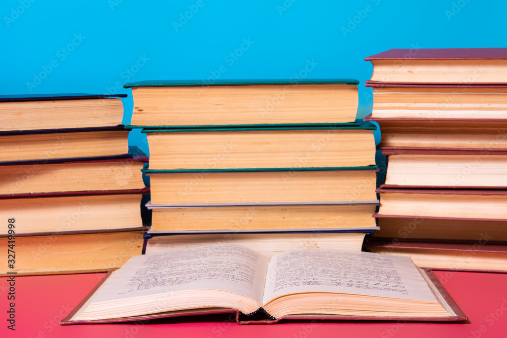 Piles of books on a pink and blue background. Piles of books on a pink and blue background.