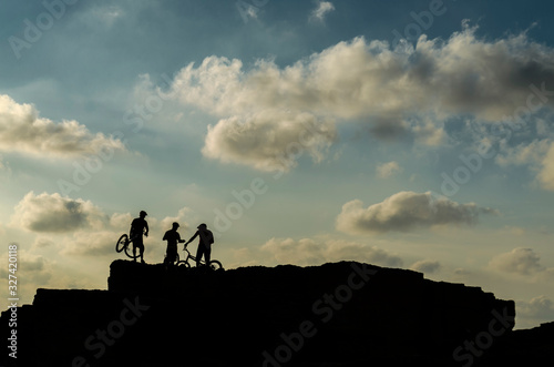 Mallorca, Spain, October 1st 2016: Shadow of three xtreme ciclysts on the rocks with blue sky background. photo