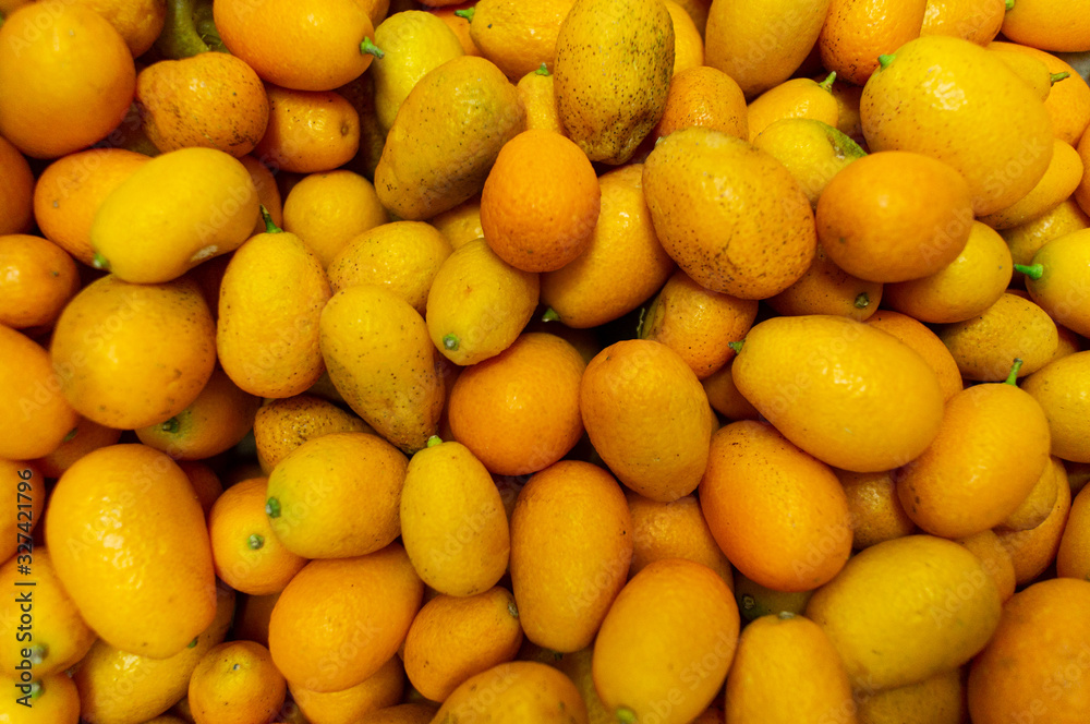 A lot of kumquats are in a drawer in the store.