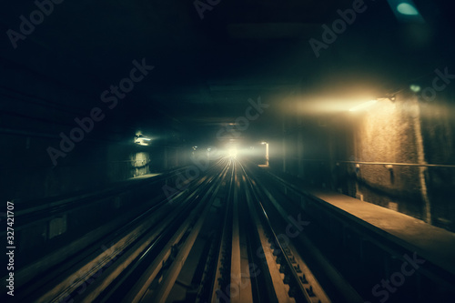 Dubai metro tunnel in blurred motion, view from first wagon, subway tracks.