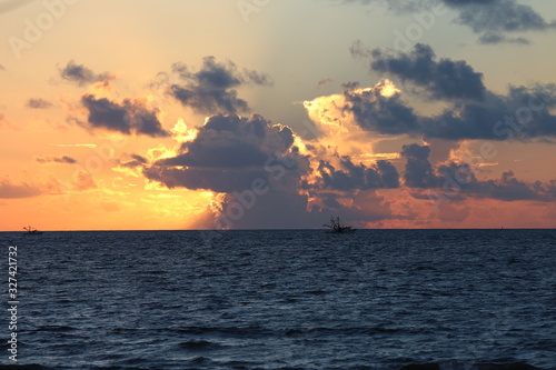Golden sunrise behind clouds over a deep blue ocean in the Atlantic Ocean