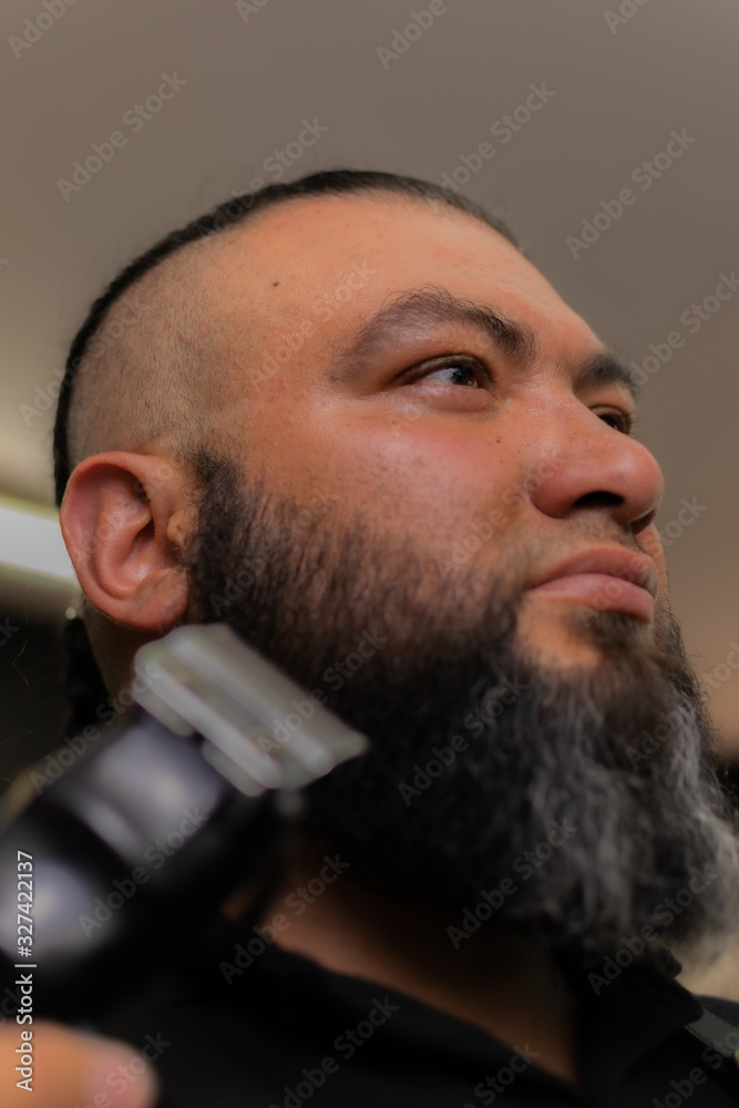 Obraz premium Latin American barber working the style with a long beard in the city of Bogotá.