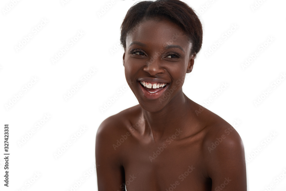 Smiling beauty. Portrait of a young and cheerful african woman laughing and looking away while standing against white background Smiling beauty. Portrait of a young and cheerful african woman laughing and looking away while standing against white background