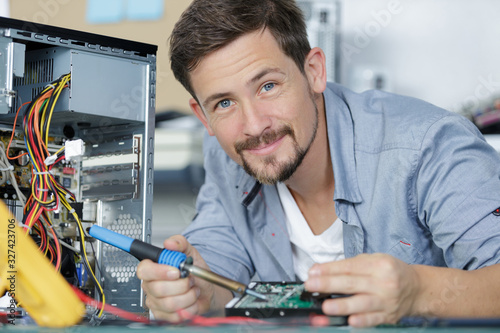 Wallpaper Mural computer specialist repairing pc late at night Torontodigital.ca