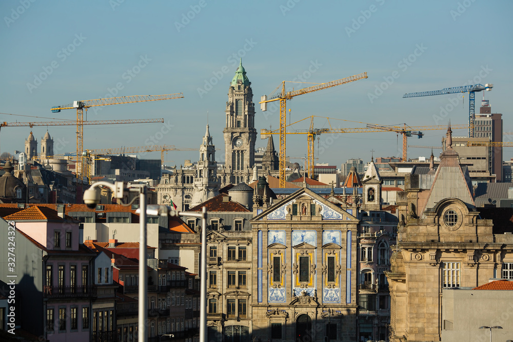 Construction cranes on the background of the old city of Porto, Portugal.