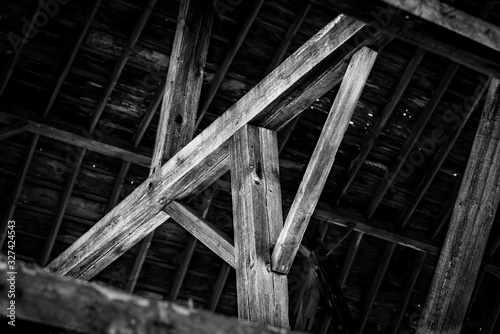 Large timbers and beam of an old barn create an abstract image in black and white
