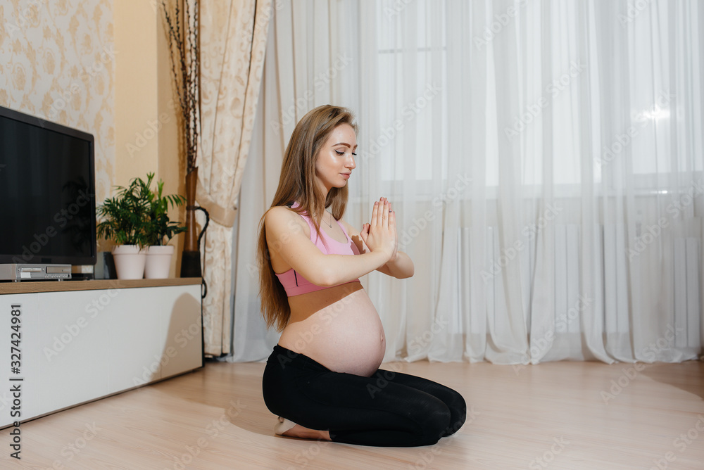 A pregnant girl does yoga at home. Health A pregnant girl does yoga at home. Health