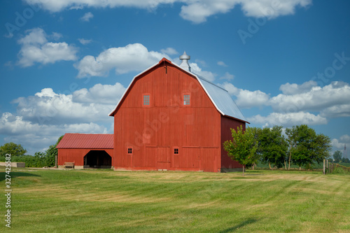 Fotografia A beautiful, very large, bright red, well kept barn by the side of the road