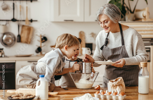 happy family grandmother and grandchildren cook in the kitchen, knead dough, bake cookies.