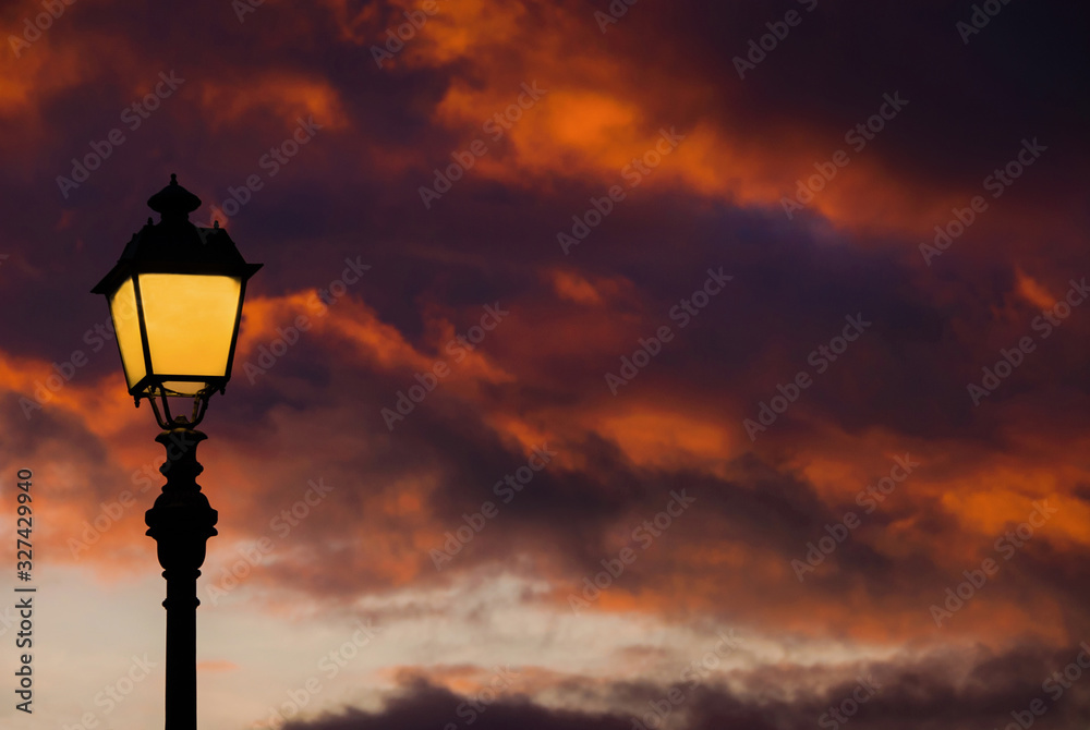 Old fashioned street lamp against beautiful sunset sky and colorful clouds (with copy space) Old fashioned street lamp against beautiful sunset sky and colorful clouds (with copy space)