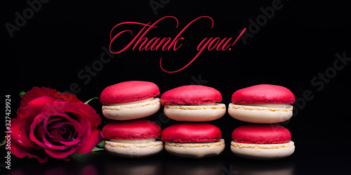 thank you  text with red macaroons and red rose on black background photo