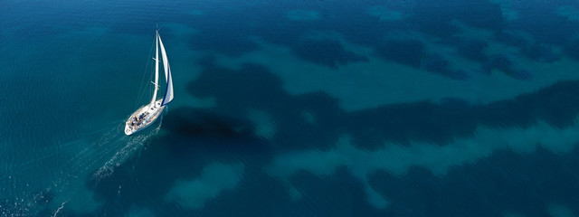 Aerial drone ultra wide photo of beautiful sail boat sailing in tropical exotic bay with emerald clear sea
