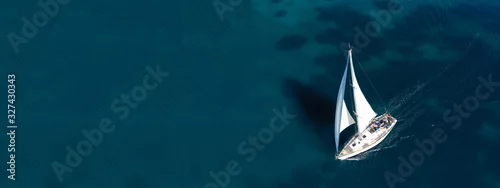 Obraz  z motywem Aerial drone ultra wide photo of beautiful sail boat sailing in tropical exotic bay with emerald clear sea