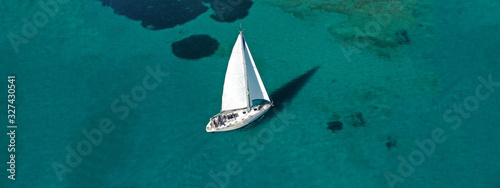 Aerial drone ultra wide photo of beautiful sail boat sailing in tropical exotic bay with emerald clear sea © aerial-drone