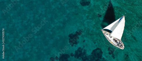 Aerial drone ultra wide photo of beautiful sail boat sailing in tropical exotic bay with emerald clear sea