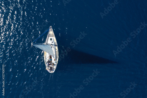 Aerial drone photo of beautiful sail boat cruising in deep blue open ocean sea