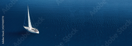 Aerial drone ultra wide photo of beautiful sail boat cruising in Aegean deep blue sea