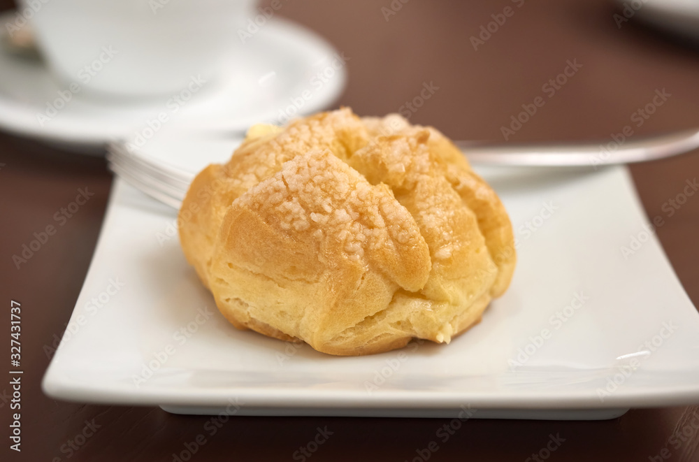 round baked eclair cake with cream on a white plate round baked eclair cake with cream on a white plate