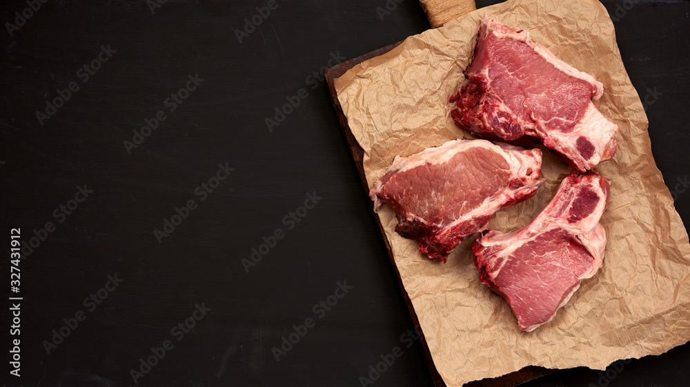 three raw juicy pork slices of meat on the rib