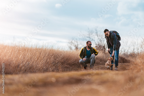 Two men play with their dog
