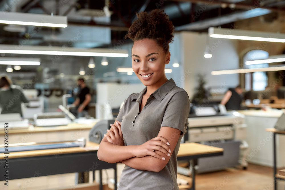 Begin a great things. Smiling african american office worker posing with folded arms Begin a great things. Smiling african american office worker posing with folded arms