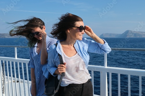 Two women mother and teenage daughter enjoying sea travel on cruise ship