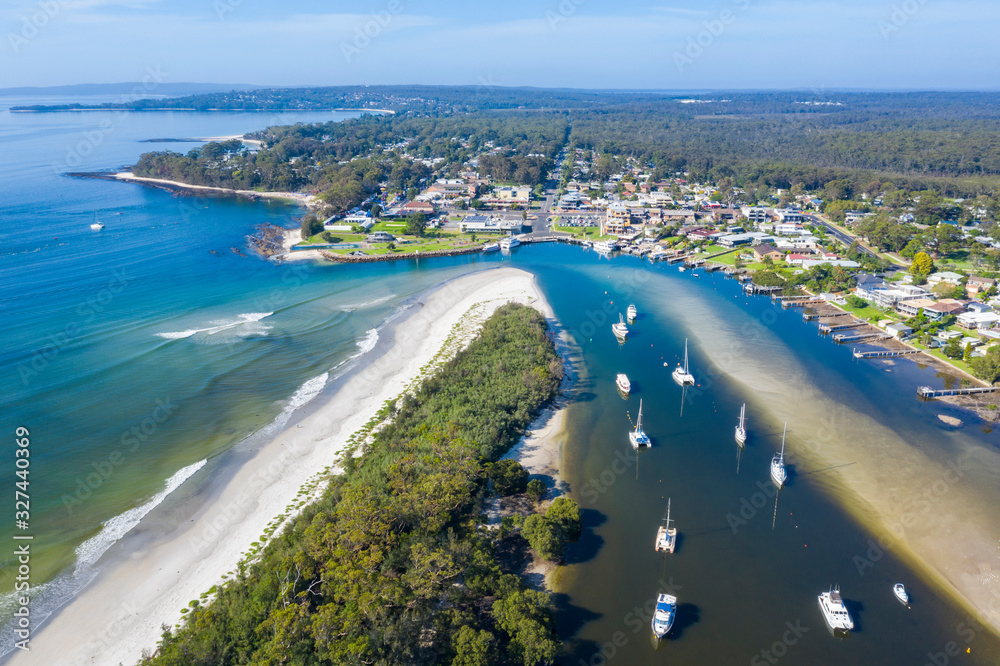 Aerial drone view of boats and yachts moored on Currambene Creek at Huskisson, Jervis Bay on the New South Wales South Coast, Australia, on a bright sunny day   