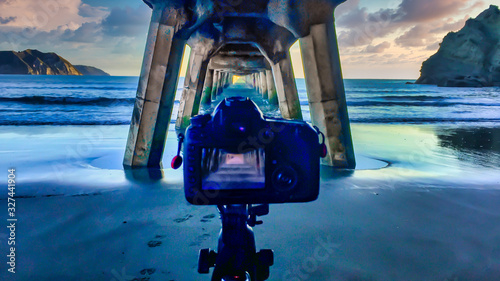 Using my second camera to capture a long exposure shot on a tripod under the historic wooden pier at Tolaga Bay at sunrise