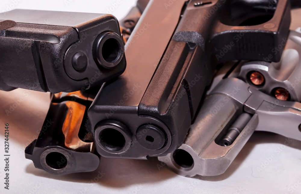 Obraz premium Four handguns, two black pistols a 9mm and a 40 caliber with a black revolver, 38 special and a silver one, 357 magnum on a white background
