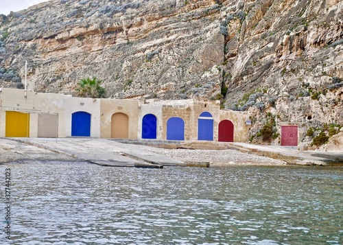 Multi-colored doors for boats. The inland sea, sometimes called Qawra in Maltese and also known as Dwejra, is a lagoon of seawater on the island of Gozo, Malta, near San Lawrenz.  photo