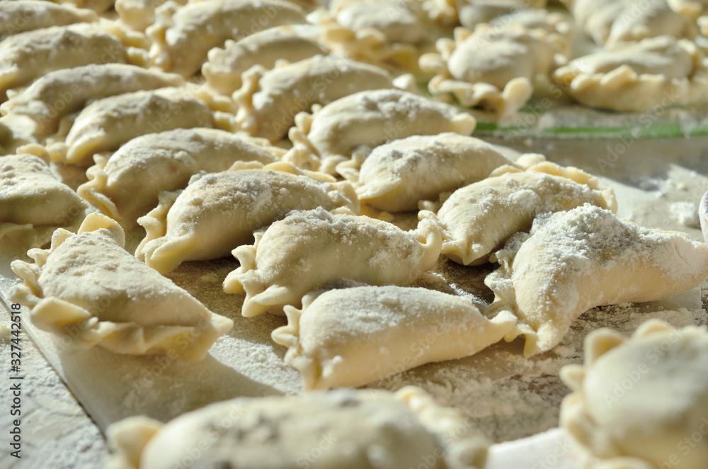 Dumplings, ravioli with cheese are on the kitchen table Dumplings, ravioli with cheese are on the kitchen table