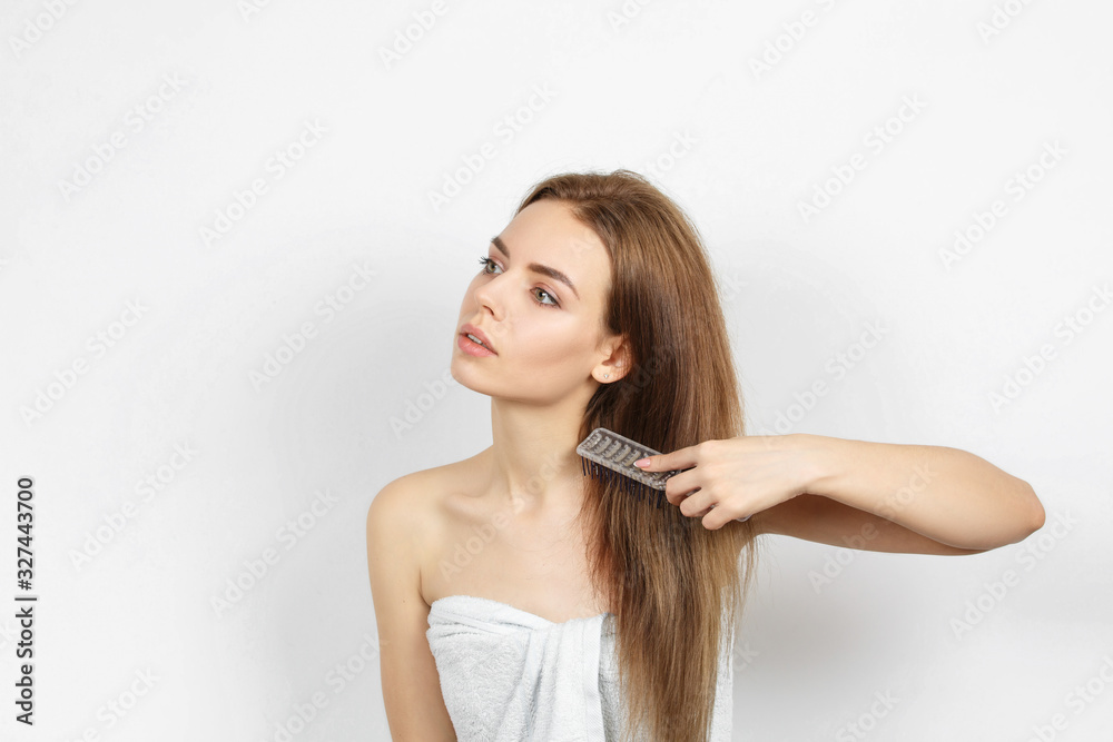 Beautiful woman in a towel combing hair. Beautiful woman in a towel combing hair.
