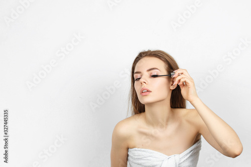 Beautiful woman in a towel making makeup