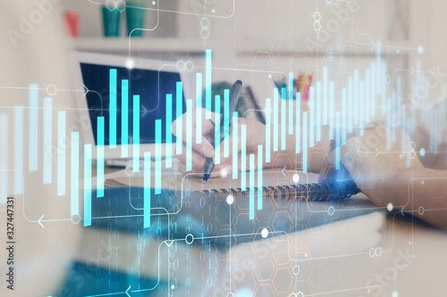 Financial graph displayed on woman's hand taking notes background. Concept of research. Double exposure © peshkova