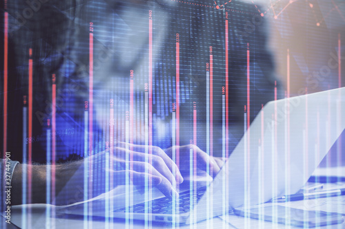 Double exposure of market chart with man working on computer on background. Concept of financial analysis. © peshkova