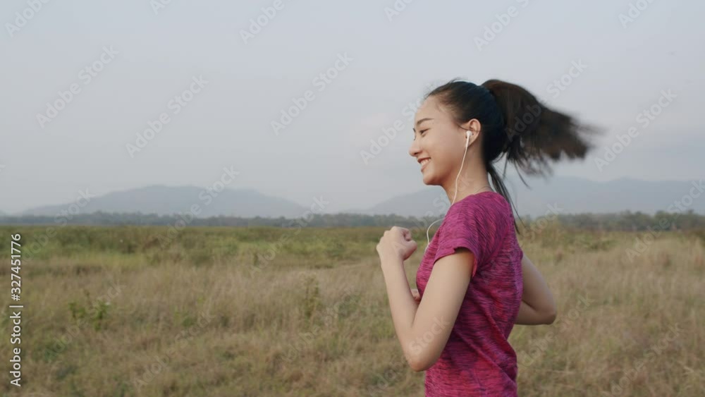 Side View of Asian women running on grass ground Mid nature. Concept wellness and lifestyle Side View of Asian women running on grass ground Mid nature. Concept wellness and lifestyle