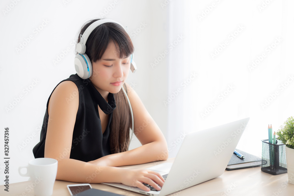 Beautiful young asian woman wear headphone smiling say hello using chat video call on laptop computer, girl relax enjoy listening music online, education learning, communication and lifestyle concept. Beautiful young asian woman wear headphone smiling say hello using chat video call on laptop computer, girl relax enjoy listening music online, education learning, communication and lifestyle concept.
