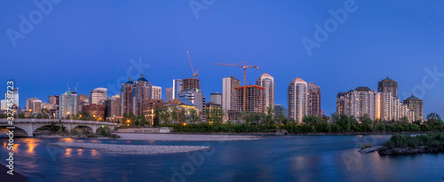 Calgary s skyline at dusk along the Bow River. Office and condominiums visible. 