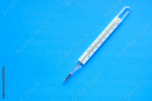 top view of thermometer on blue background 