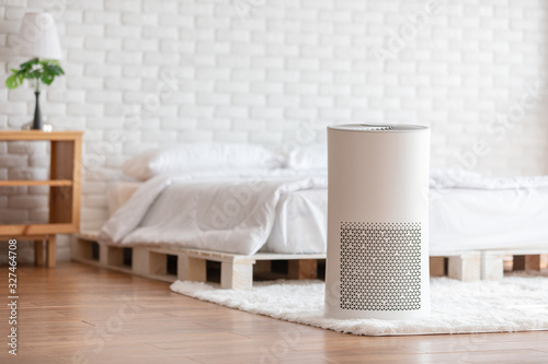Air purifier in cozy white bedroom for filter and cleaning removing dust PM2.5 HEPA in home,for fresh air and healthy life,Air Pollution Concept photo