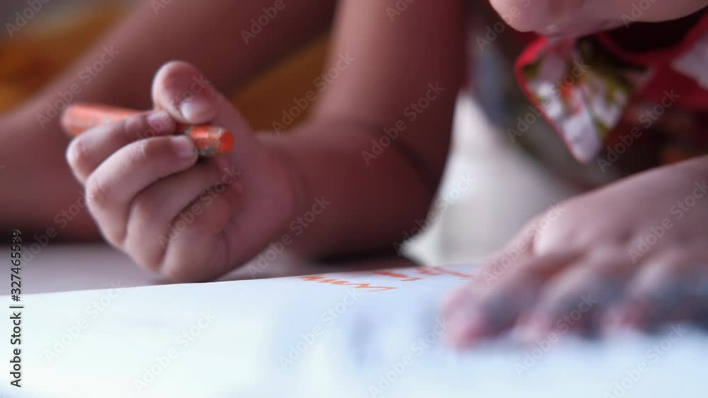 Close up of child girl daring on paper with color pencils Close up of child girl daring on paper with color pencils