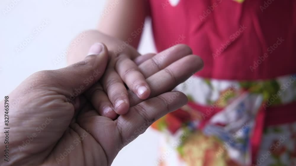 close of father hand holding child hand close of father hand holding child hand